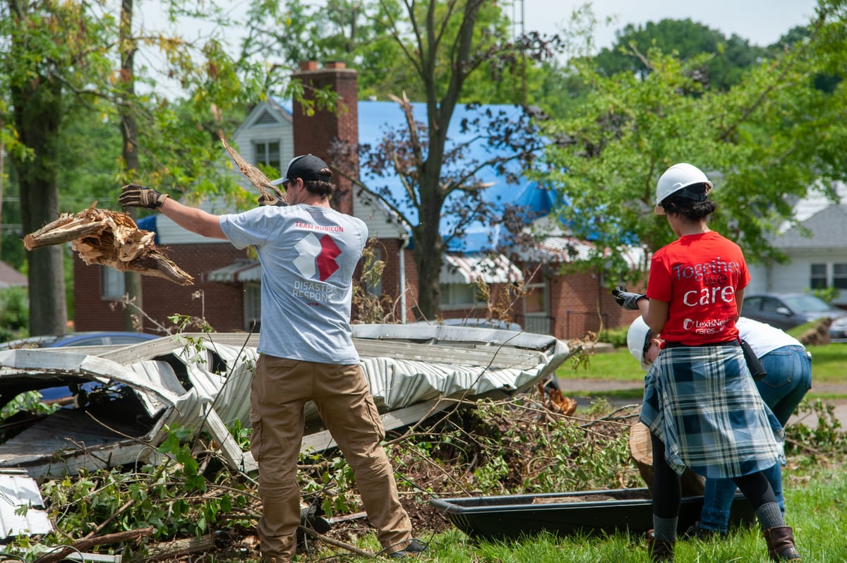 Workers removing fallen trees and debris after a storm